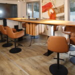 Höhenverstellbarer Konferenztisch aus Massivholz mit unsichtbar integriertem Kochfeld bei Müller-Moers: New Work trifft Genusskultur